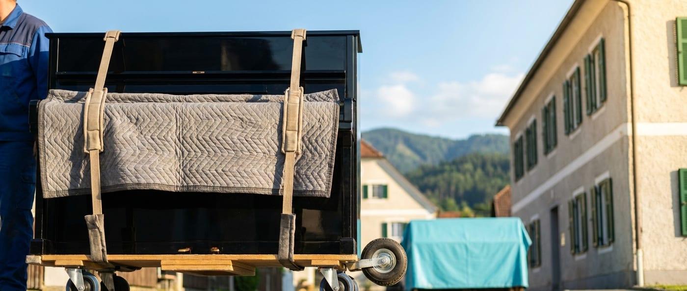 Klavier mit Polstergurten auf dem Transportroller gesichert — Klaviertransport durch SpeedTransport